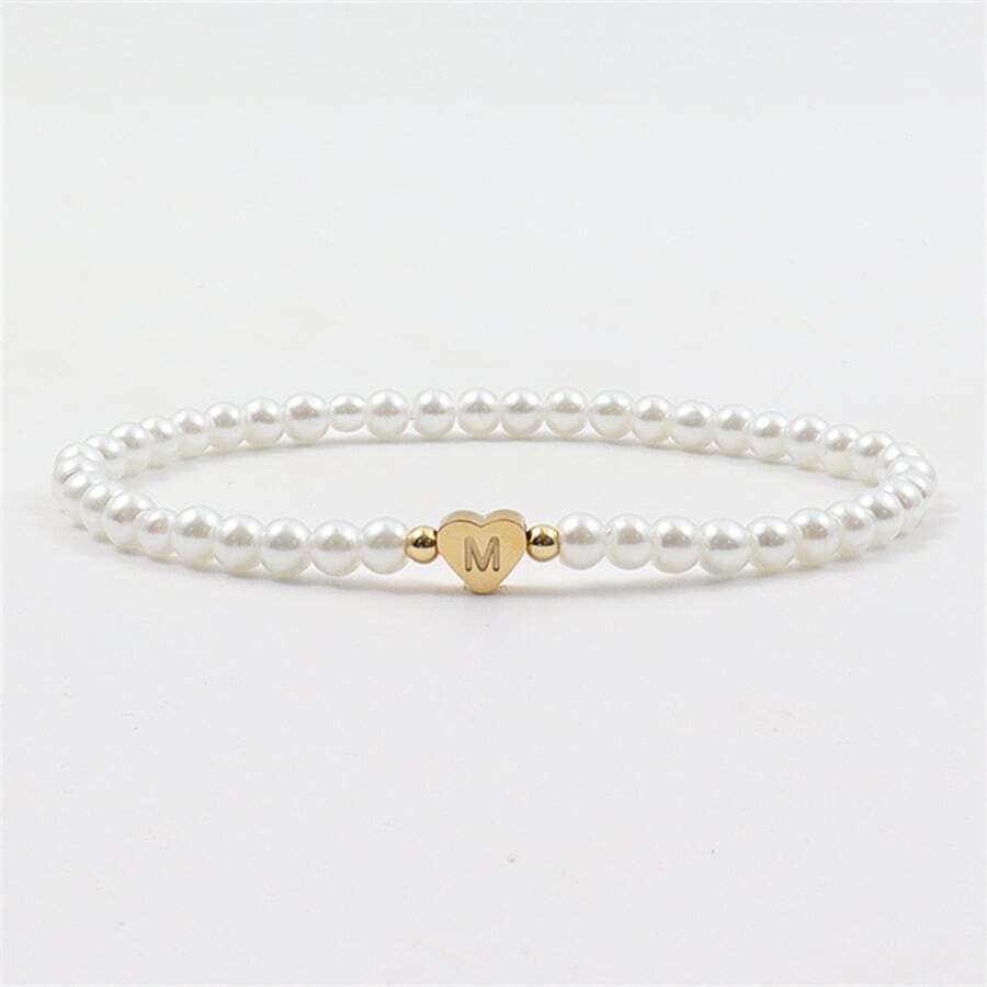 Elegante armband met parels en een gepersonaliseerd hartdetail, ideaal voor een verfijnde look.
