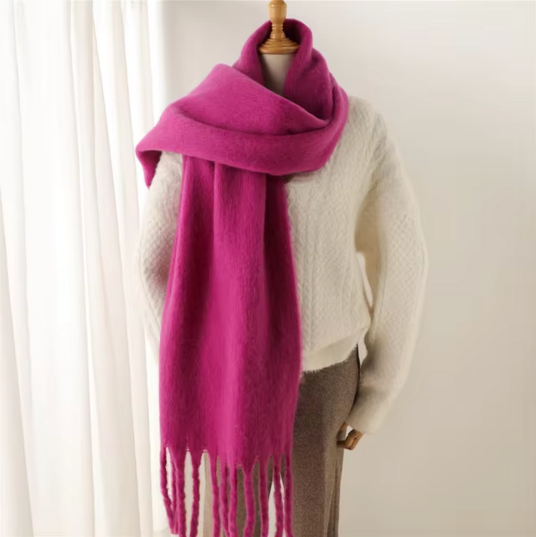 Luxe winter sjaal van kasjmier met speelse franjes, gewikkeld om een jas.