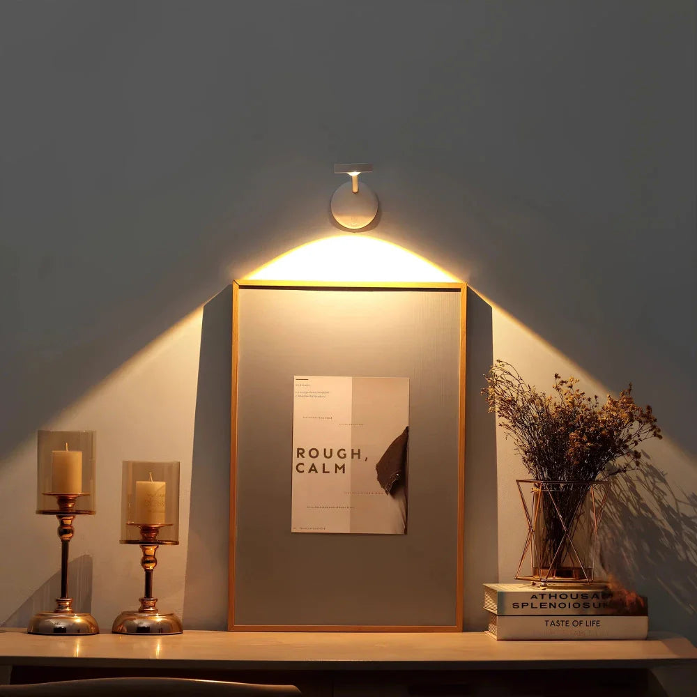 Noor Motion Spotlight verlicht een kunstwerk boven een tafel.
