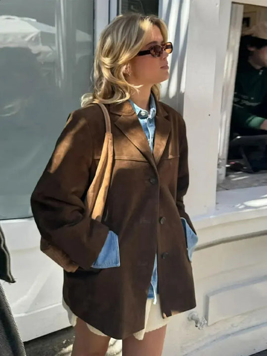 Vrouw draagt een suède dames blazer met vintage look, perfect voor een chique en tijdloze uitstraling.