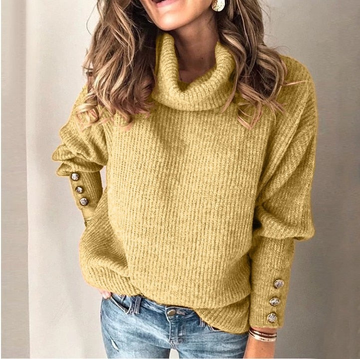 Lotte Vrouwelijke warme coltrui met een gebreid ontwerp en knopen op de mouwen. Deze trui biedt comfort en stijl, perfect voor een gezellige look tijdens de koudere maanden.