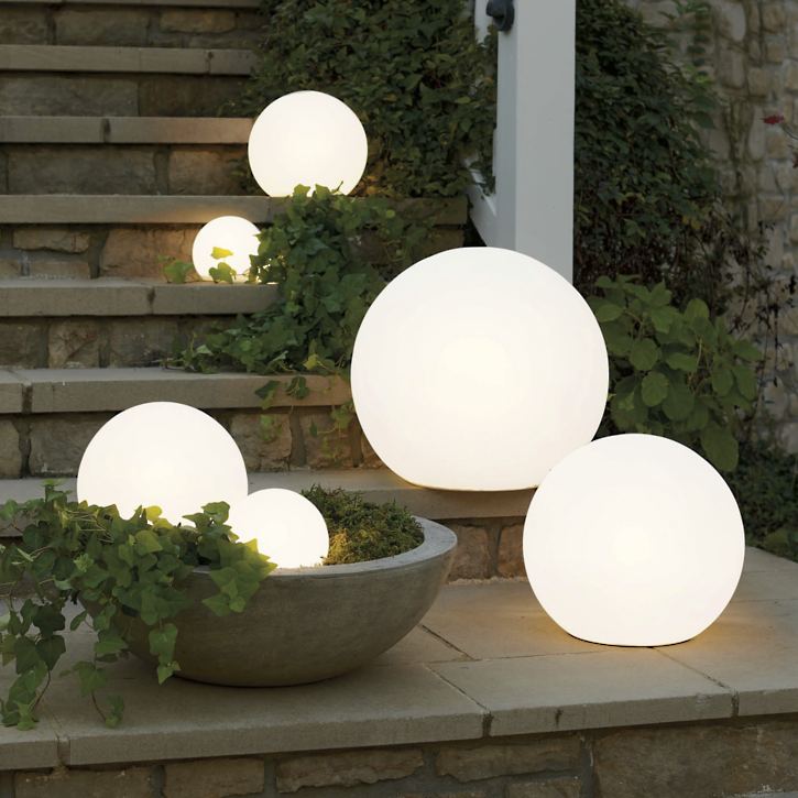 Drie Luna Tuinlampen geplaatst op een stenen trap bij de voordeur.

