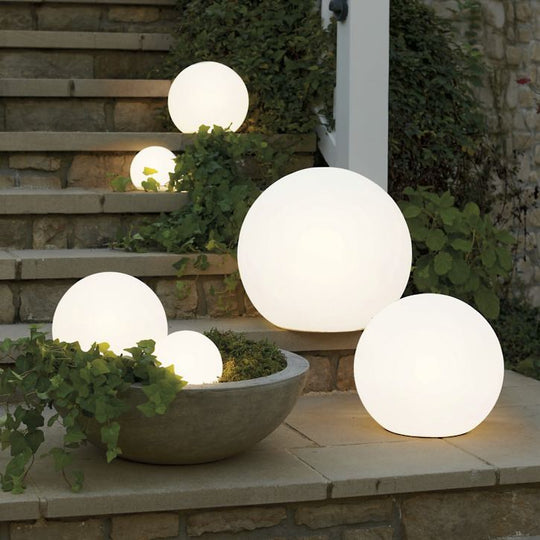 Drie Luna Tuinlampen geplaatst op een stenen trap bij de voordeur.
