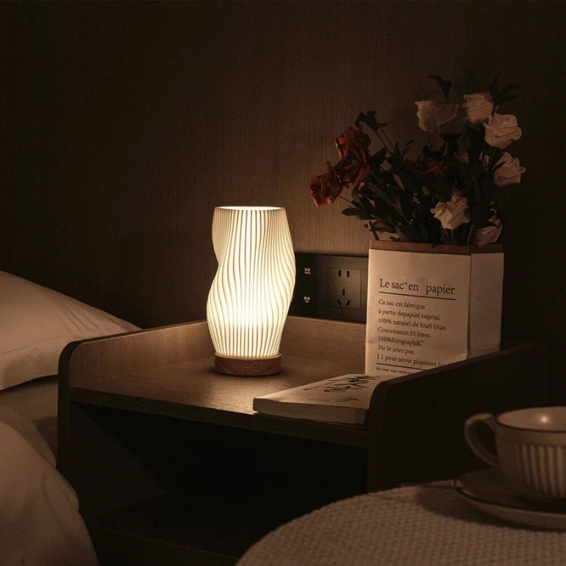 De lamp gecombineerd met moderne decorstukken op een tafel.
