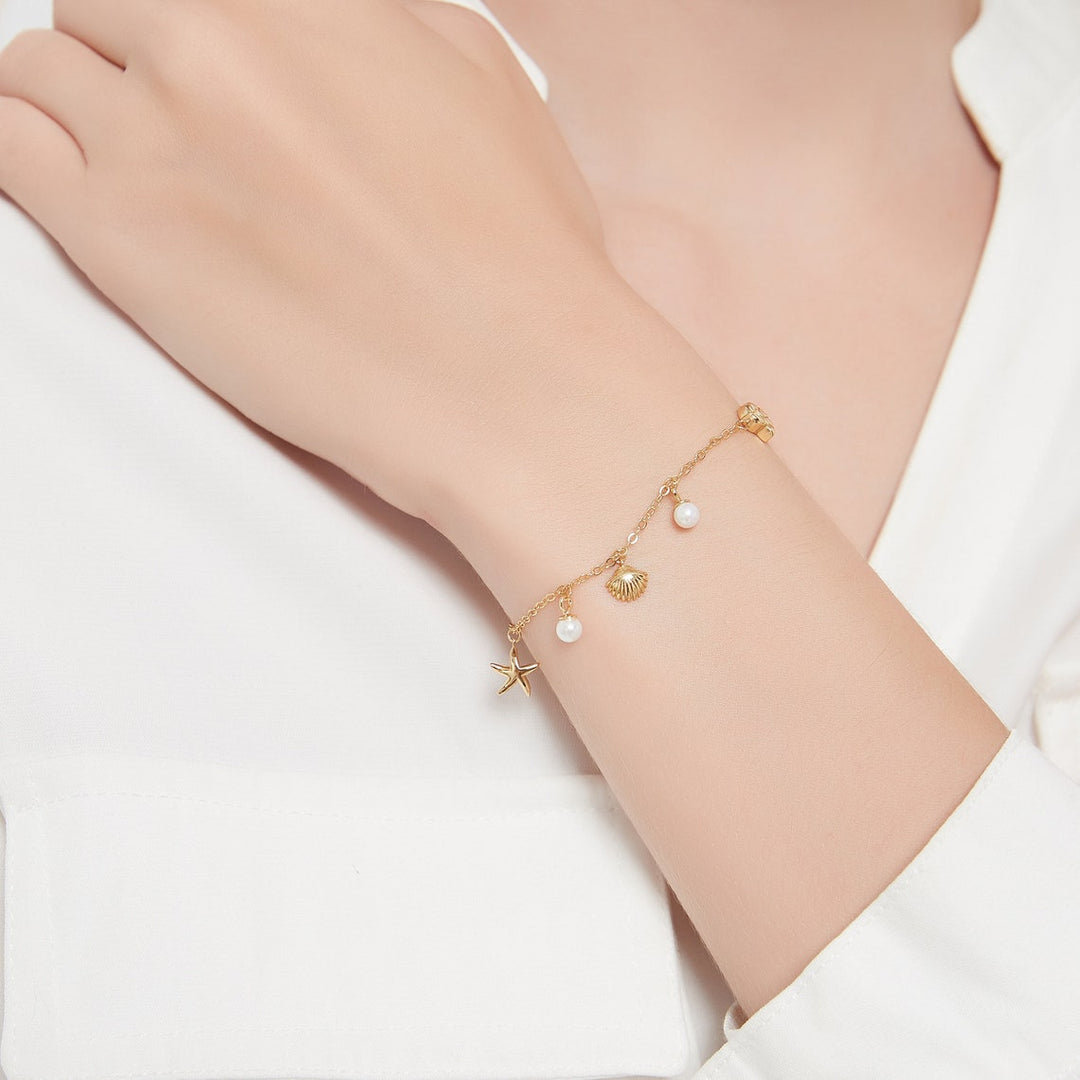 Noor dames stijlvolle bedelarmband met verfijnde details zoals schelpen en parels, perfect voor een elegante uitstraling.
