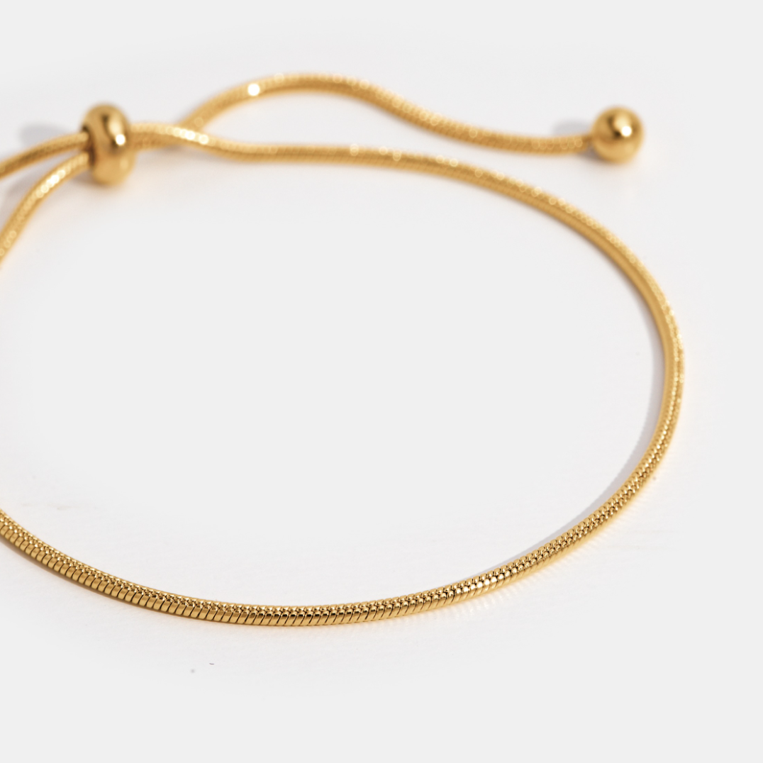 Polsaccessoire in een minimalistische stijl met verfijnde gouden tinten.
