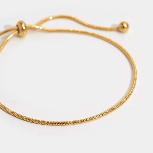 Polsaccessoire in een minimalistische stijl met verfijnde gouden tinten.
