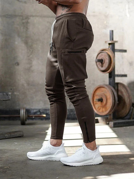 Grijze jogger gecombineerd met sportieve witte sneakers.
