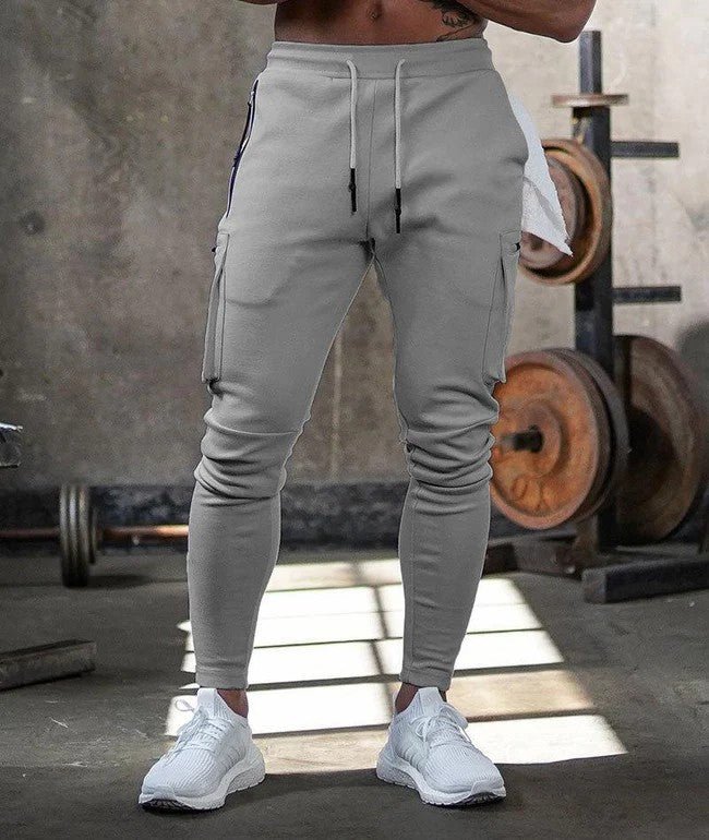 Grijze joggingbroek gedragen in een sportschoolomgeving.
