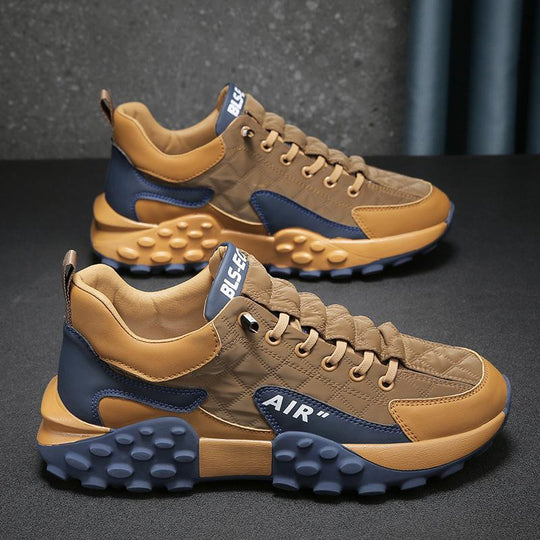 Camel en marineblauwe sneakers met een robuust design.
