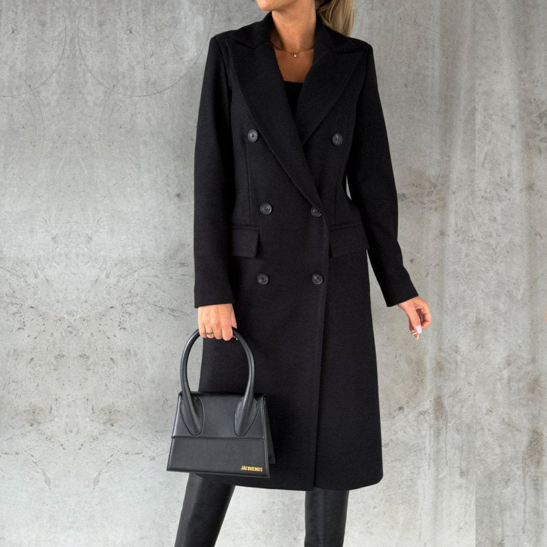 Elegante zwarte jas gepresenteerd tegen een neutrale achtergrond.

