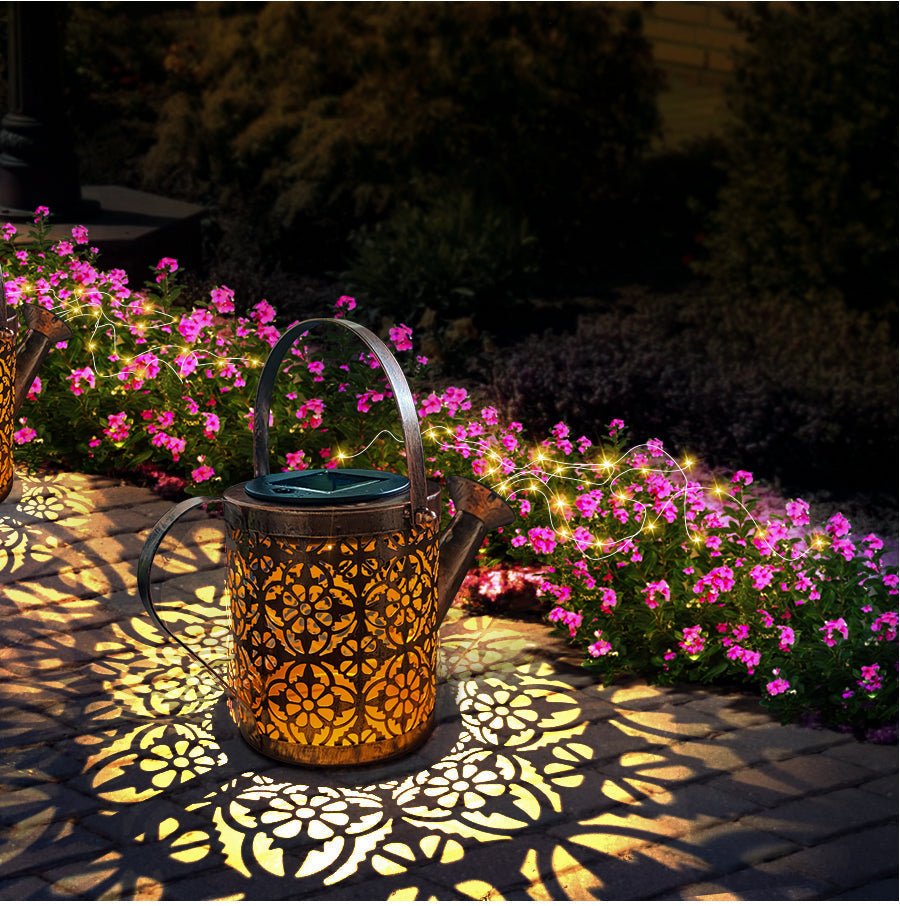 Sproeiende LED-lamp in de vorm van een gieter, zorgt voor een bijzondere en speelse verlichting in de tuin.